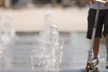 Jugendlicher spielt mit Wasserstrahl