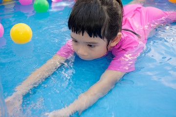Fototapeta na wymiar Baby girl playing in kiddie pool