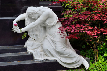 Frauenfigur aus weißem Marmor vor Grabmal