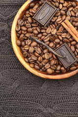 Coffee beans with spices in a wooden bowl.