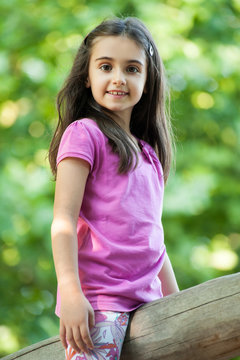 Cute little girl straddling a wooden pole