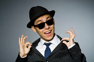 Young man in classic striped costume and hat isolated on gray