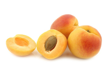 fresh colorful apricots and a cut one on a white background