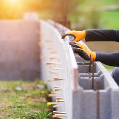 Bricklayer putting down another row of bricks in site
