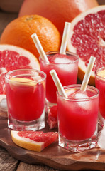 Pink grapefruit drink with pulp, selective focus