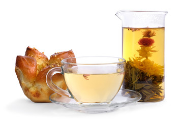 Brewed floral tea and a bun, isolated on white background.
