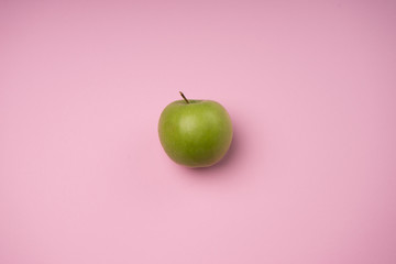 Grüner Apfel auf pastellfarbenen hintergrund