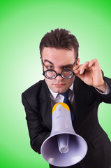 Young businessman with loudspeaker on white