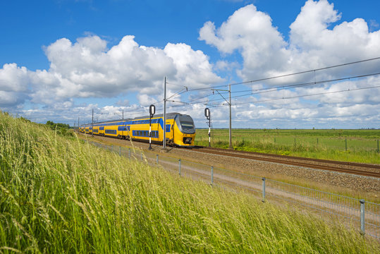 Fototapeta Electric train driving through nature in spring 