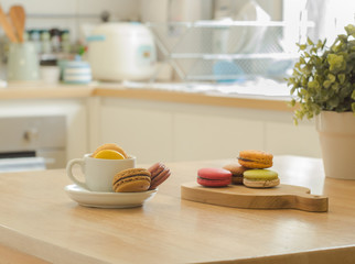 French macarons on wooden table in a kitchen