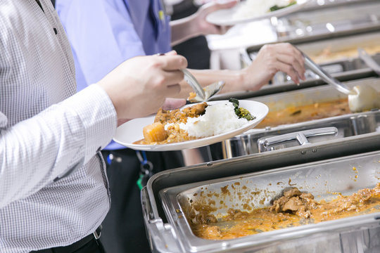 people choosing food from table on catering and buffet for an event party or wedding reception