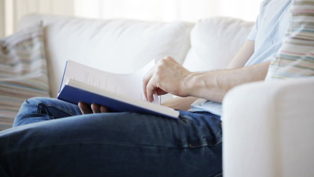 close up of man reading book at home