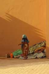 Eine Bleibe auf der Stra&szlig;e/eine Frau richtet sich ihr Nachtlager auf einer Stra&szlig;e in Marokko ein