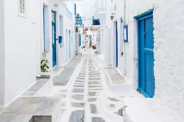 Foto op Aluminium Mykonos, Greece - Traditional whitewashed street of Mykonos town with blue windows and doors on a sunny summer morning. Empty alleyway at sunrise © zgphotography