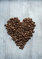 heart of coffee beans on the wooden background