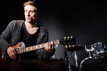 Obraz premium Man playing guitar in dark room