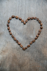 Heart of coffee beans on wooden background