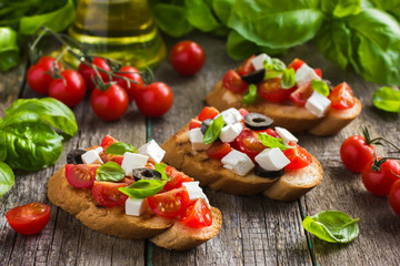 Fototapeta na wymiar bruschetta with tomato, feta cheese, olives and basil