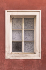 Old window on an old red stucco wall