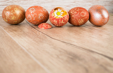 Easter wooden background with row of colored eggs, text space