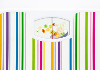 Bathroom scale with bowl of fruits on dial with no numbers