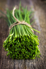 bunch of  chives on a wooden cutting board