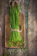 bunch of  chives on a wooden cutting board