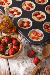 cooking berry muffins with fresh strawberries, vertical
