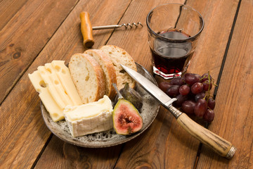 snack of swiss and french cheese with figs, grapes and wine