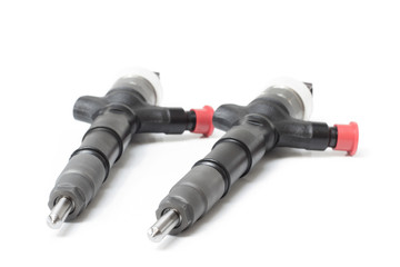 Two new electromagnetic injector for diesel fuel lying on a white background