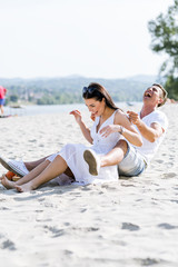 Fototapeta premium Romantic young couple sitting at a beach
