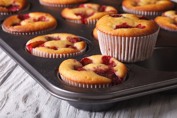 muffins with strawberries close up in baking dish. horizontal
