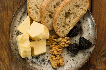 plate of cheddar with walnuts and dried prunes