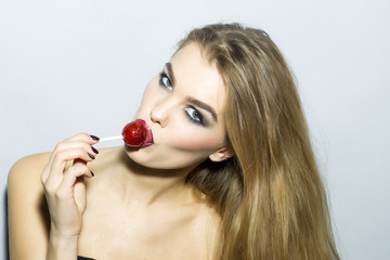 Captivating young blonde woman portrait with sugar candy