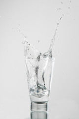 Splash com gelo caindo no copo de água