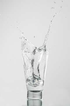 Splash com gelo caindo no copo de água