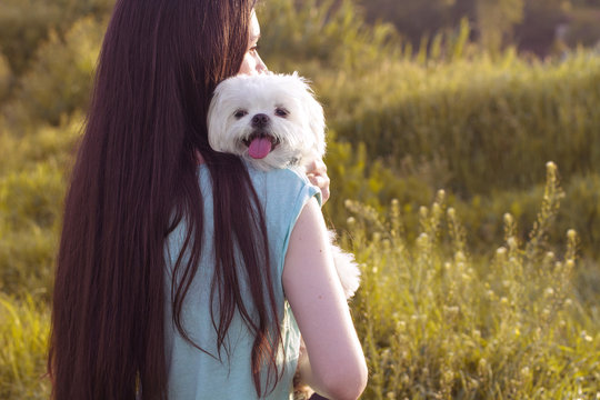 Beautiful brunette with a young dog enjoying a beautiful day