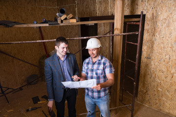 Architect and Foreman Inspecting Building Plans