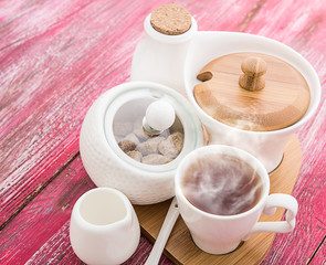 Tea cups with teapot on old wooden table