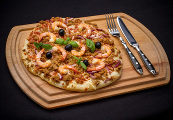 Tuna pizza with prawn and olive, cutlery