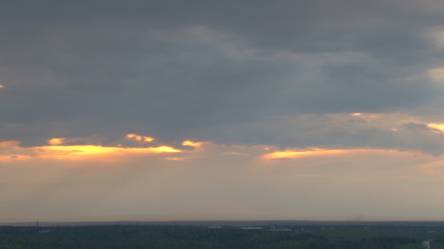 Sunset and rain clouds/Rain clouds move quickly over the forest in the evening. It's raining. Time lapse
