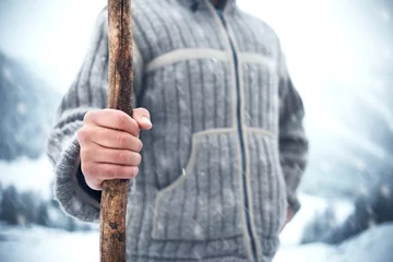 Crédence de cuisine en verre imprimé Cercle polaire Homme tenant un bâton de bois dans le froid de l& 39 hiver lorsqu& 39 il neige