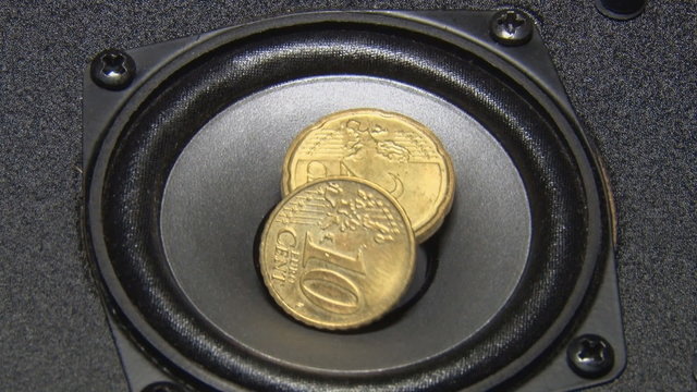 Speaker and coins/Two coins cents jumping on the speaker. Speaker volume.