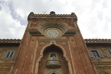 Fototapeta na wymiar Sammezzano Ancient Castle in the heart of Tuscany, Italy, external facade with a big clock