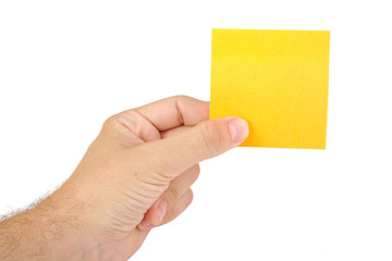 Hand holding a yellow notepaper or postit isolated on a white