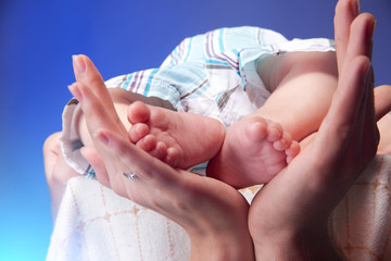 Closeup  Baby legs. Legs newborn in parents hand