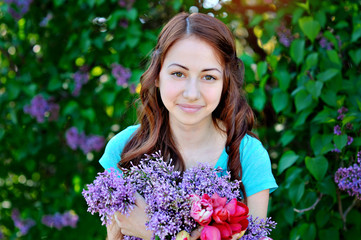 beautiful woman with a bouquet of lilacs and tulips walking