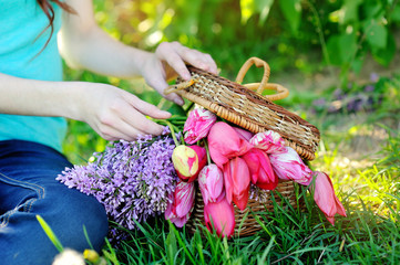 beautiful bouquet of red tulips and lilac in a basket