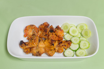 grilled chicken with cucumber on the white dish
