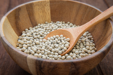 White pepper in wooden bowl